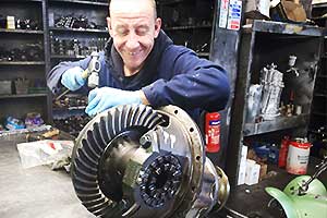 distance front view of a dismantled differential rebuild on a metal bench showing the diff casing, gears and bearings with our specialist reconditioning it