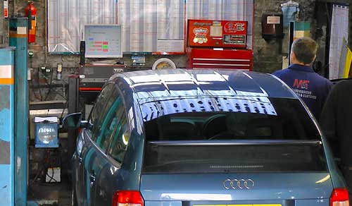 rear distance view of our sheffield mot testing center with a metalic sky blue audi just passing its mot test