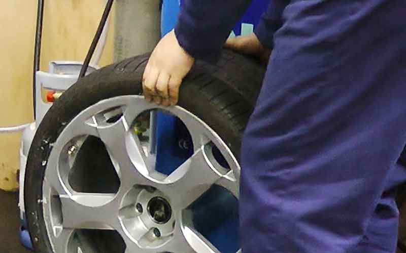 close up of a new intricately spoked alloy wheel being fitted with a new tyre